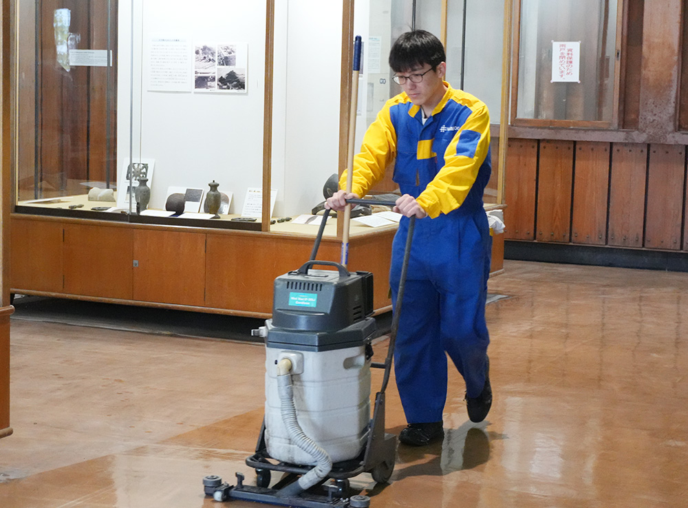 洗浄機で床を磨く社員