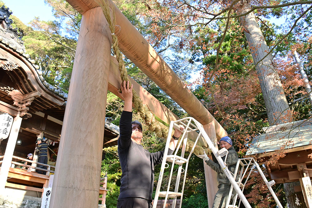 しめ縄を鳥居に掛ける氏子ら