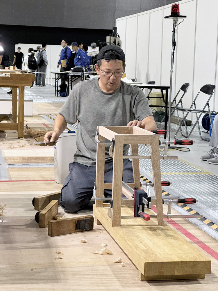 アビリンピックで花台を製作する山原さん(県提供)