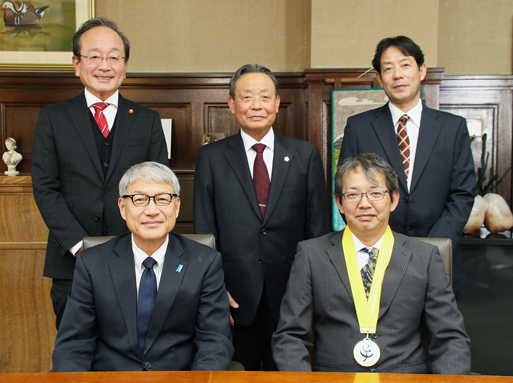 金メダルをかけた山原さん(前列右)と宮﨑知事(同左)、和中代表取締役(後列中央)ら
アビリンピックで花台を製作する山原さん(県提供)