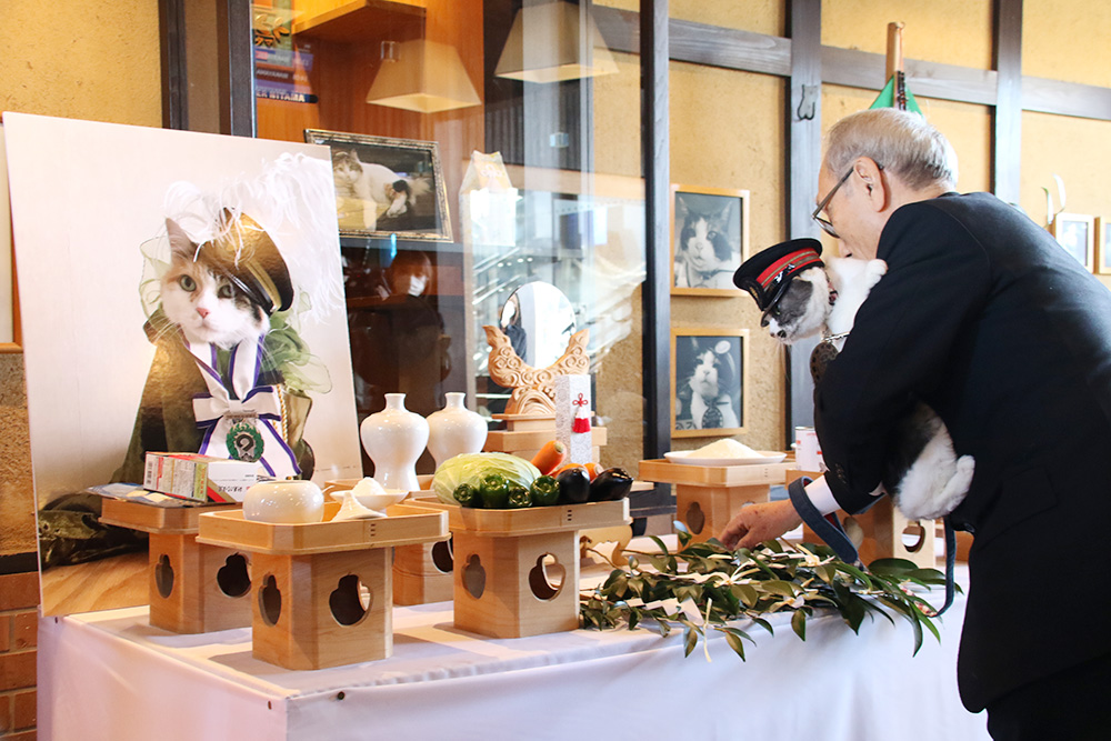 ニタマの遺影が飾られた祭壇に玉串をささげる小嶋社長とよんたま