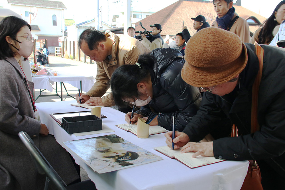 記帳所に列を作る参列者