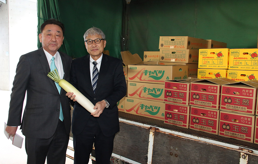 寄贈された食材の前で川﨑理事長㊧と宮﨑知事