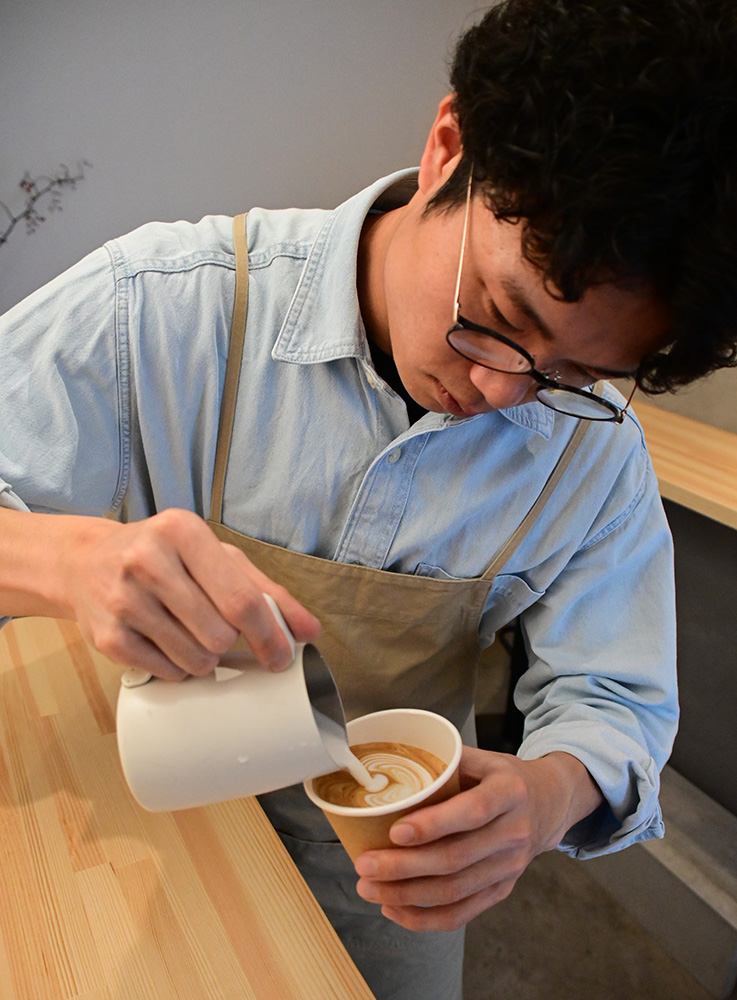 ミルクを注ぐ田中さん