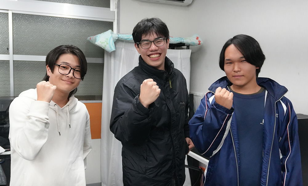 ガッツポーズをするｅスポーツ部の皆さん（左から諏訪さん、嵜山部長、池田さん）