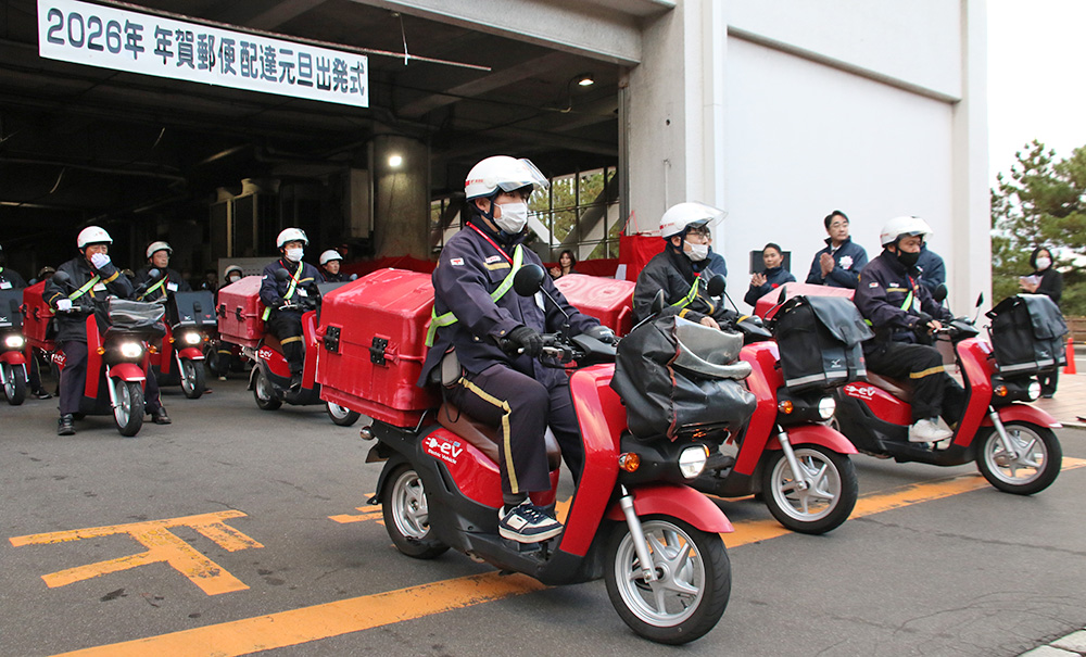 和歌山中央郵便局からバイクで出発する配達員ら