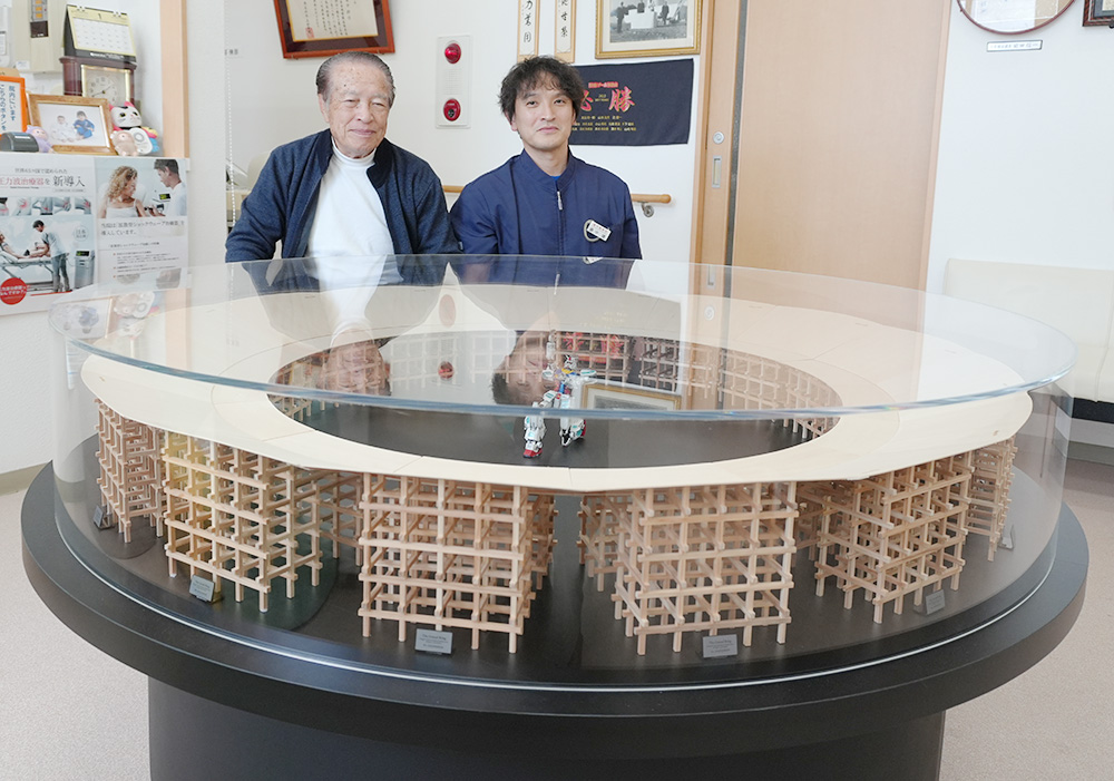 大屋根リングの模型を前に畠中耕作名誉院長㊧と畠中院長