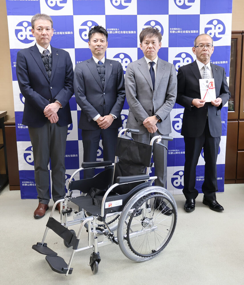 寄贈した車いすと（左から）矢田課長、武田課長、新谷部長、中村常務理事