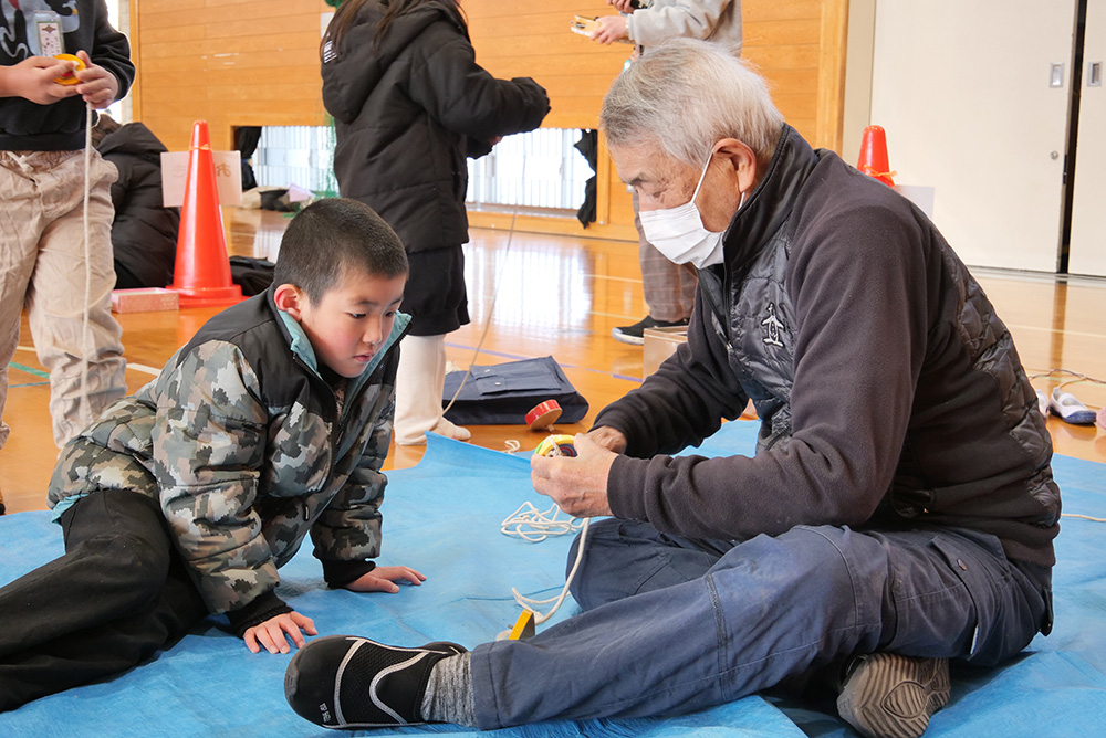 こま回しを教わる児童