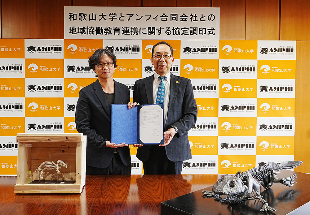 協定書を手に佐々木代表㊧と本山学長