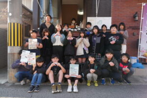 「米丸」の前で笑顔の児童たち