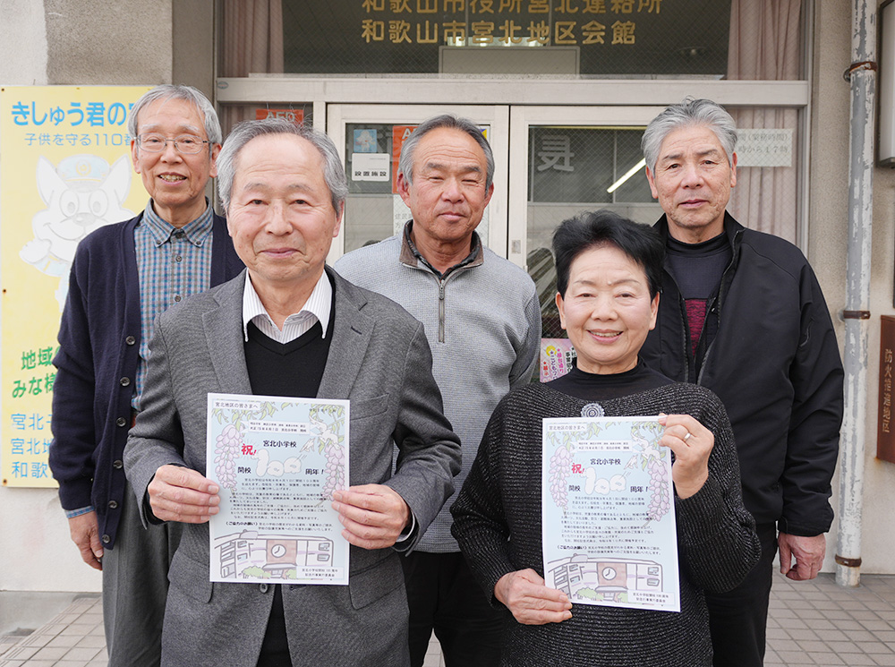 100周年を祝うポスターを手に実行委員会の皆さん(前列左:中嶋実行委員長)