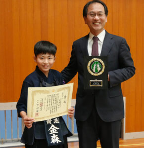 近畿大会の表彰状を手にする金森さん㊧と小杉代表