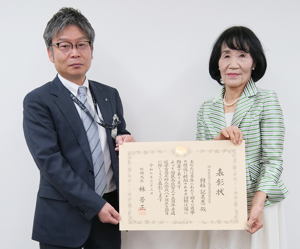 表彰状を手に笑顔を見せる朝稲さん㊨と山田局長