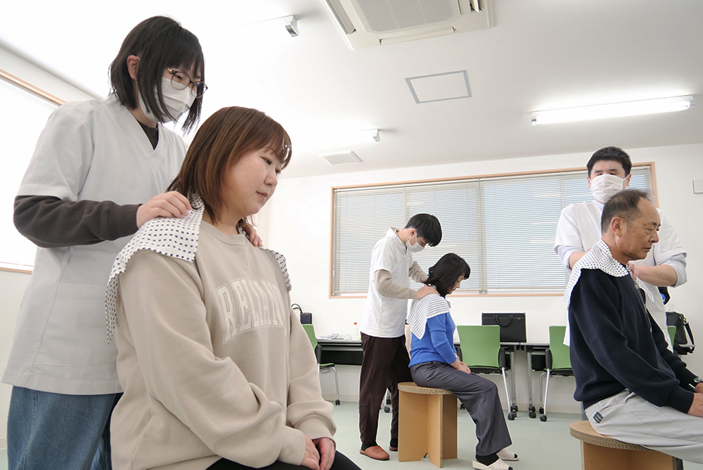 従業員の体の凝りを丁寧にほぐす川西さん（中央奥）と柴田さん㊧