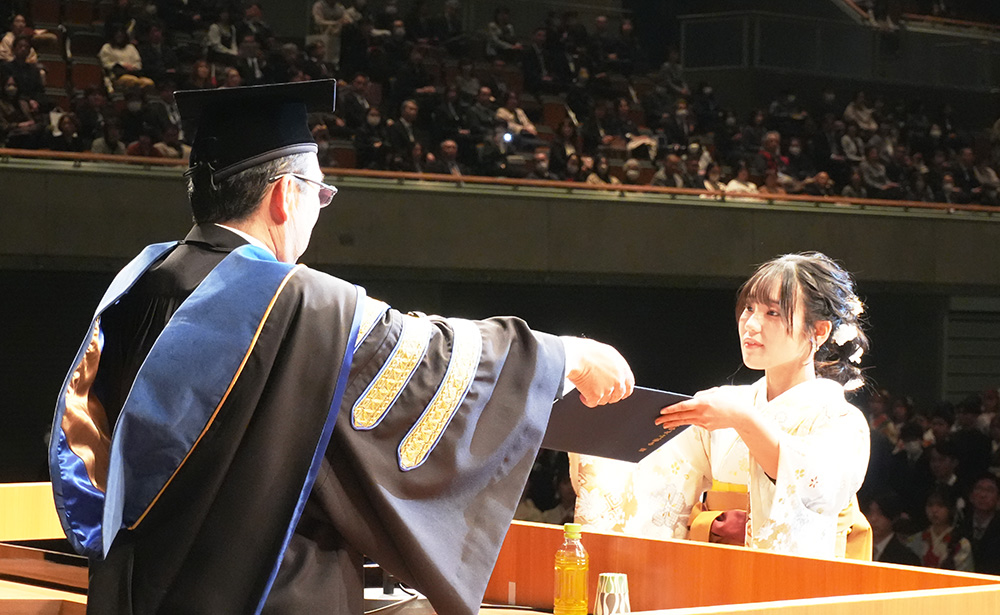 
本山学長㊧から学位記を受け取る経済学部の卒業生