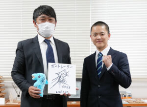 出口さんのサインを手に中本監督㊧とガッツポーズの出口さん