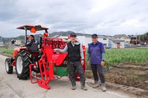 自動操舵トラクターと吉村代表(中央)、吉村享専務㊨