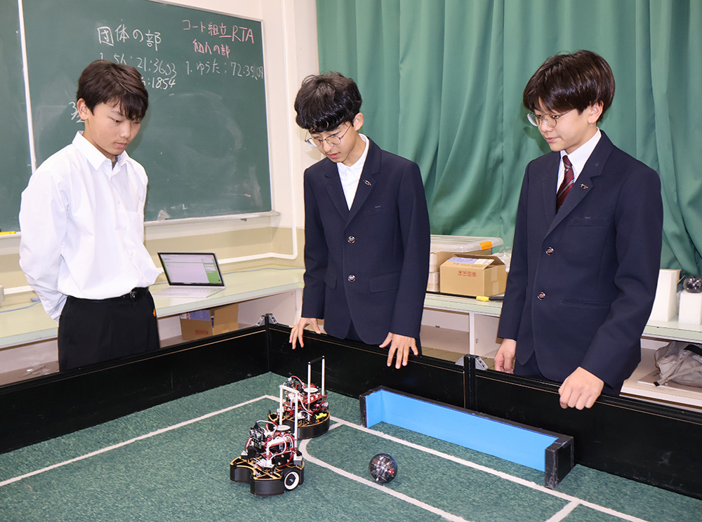 ロボットの動きを確認する（左から）田村さん、鈴木さん、北島さん