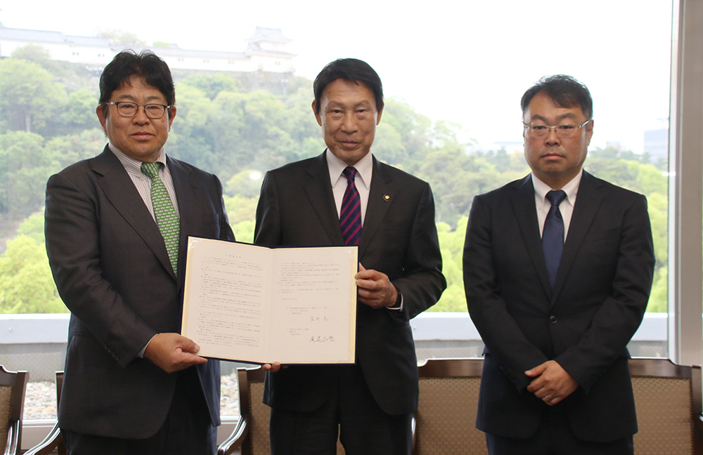 協定書を手に（左から）笠井会長、尾花市長、鹿島センター長