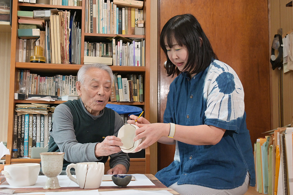 橋爪さん㊧に教わりながら筆で継ぎ目を塗る岩本さん