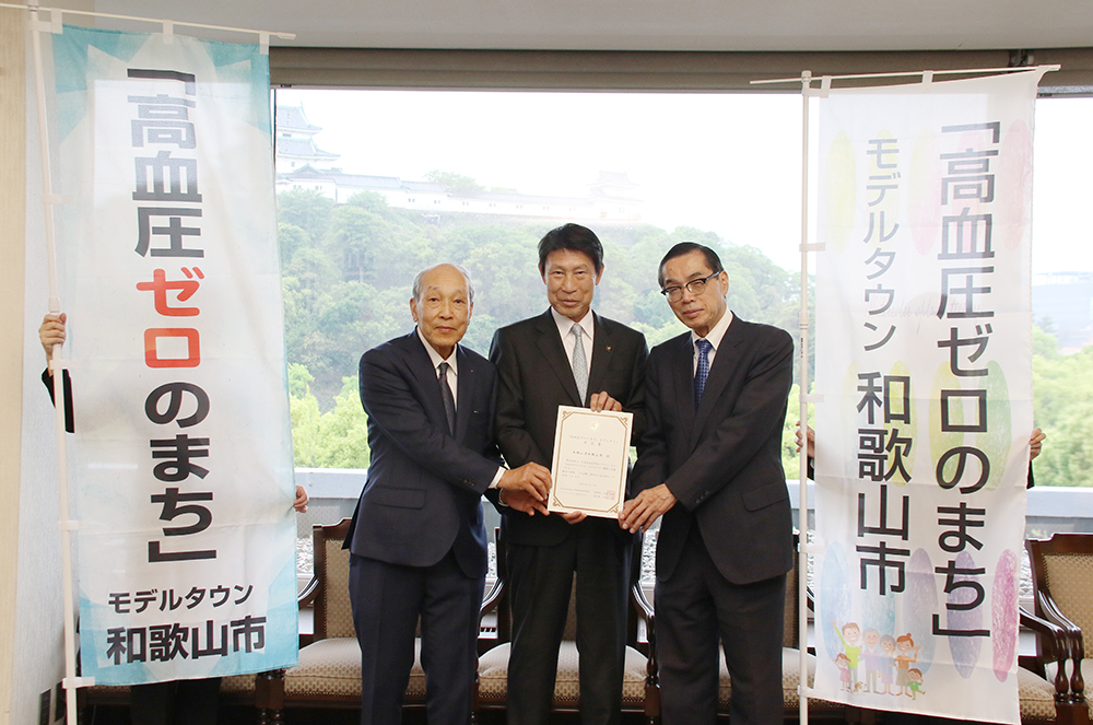 承認書を手に（左から）有田名誉教授、尾花市長、宮下前学長