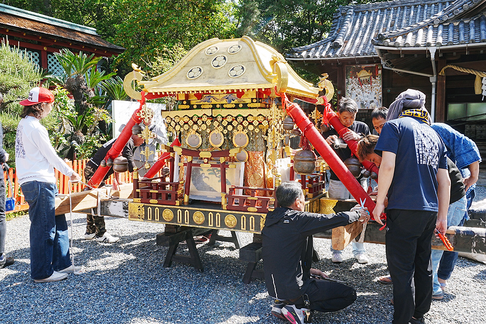 担ぎ棒を取り付ける同保存会の関係者
