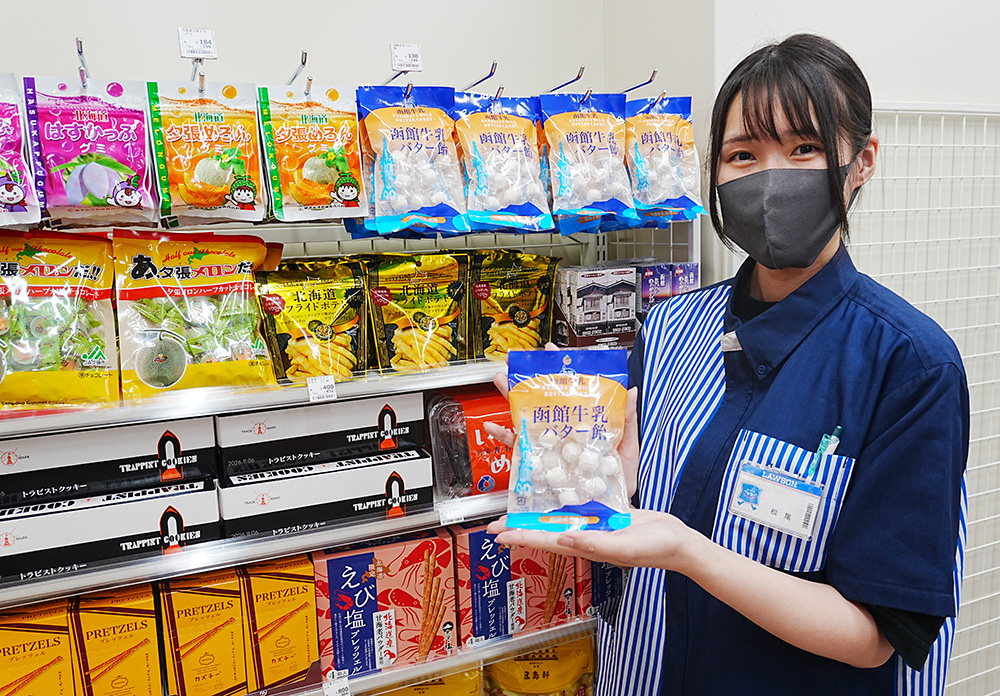 北海道のご当地商品を持つスタッフ