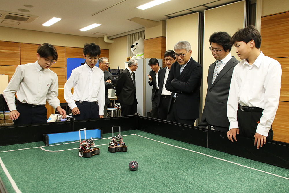 ロボットのデモンストレーションを見る宮﨑知事（右から３人目）ら