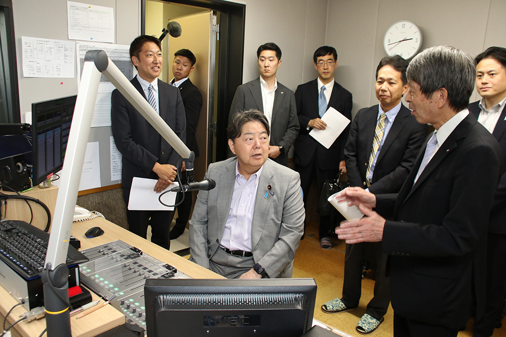 緊急時に１人で放送できるスタジオで中村社長（手前右）から説明を受ける林総務相（同中央）