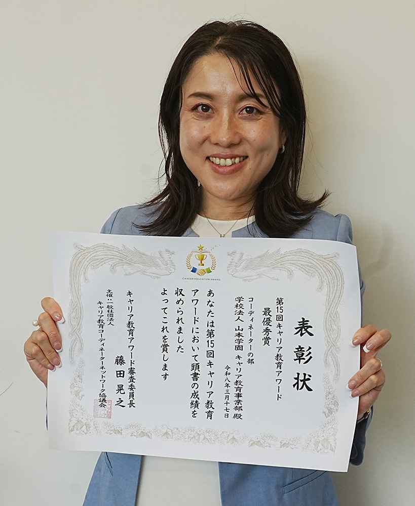 表彰状を手に笑顔の山本さん