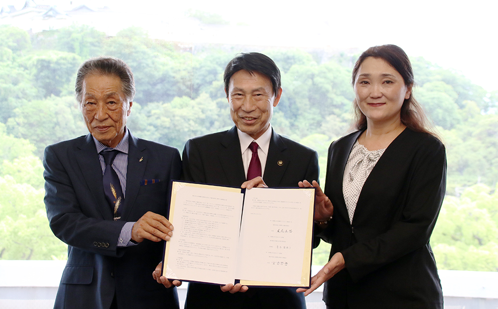 協定書を手にする(左から)古市会長、尾花市長、青木理事長