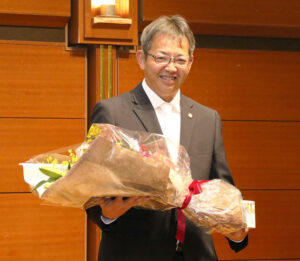 花束を手に笑顔の山原さん
