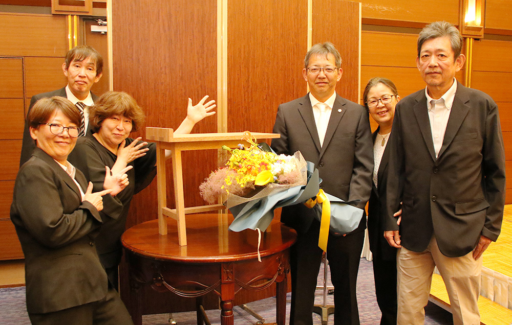 出席者と記念撮影する山原さん(右から3人目)