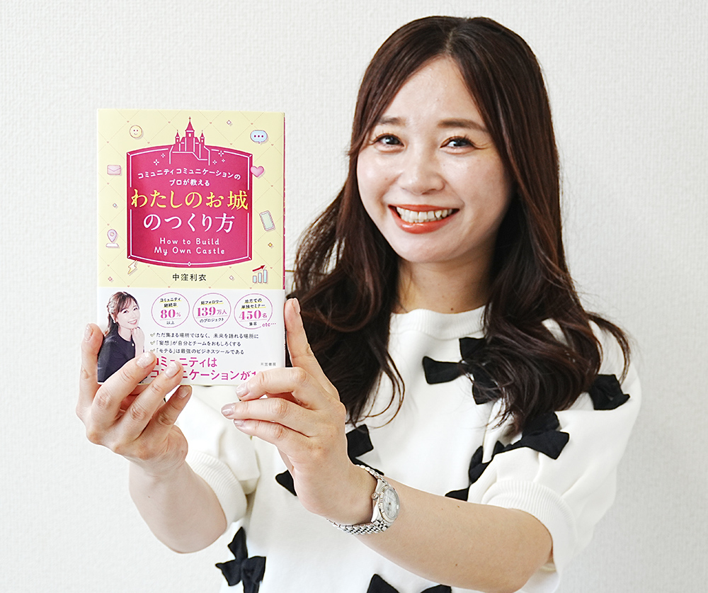 笑顔で著書をＰＲする中窪さん