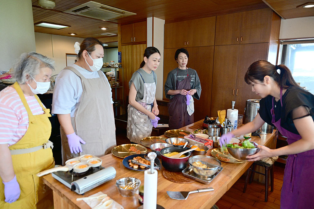 立畑さん㊨の指導で楽しくスパイス料理を学ぶ参加者