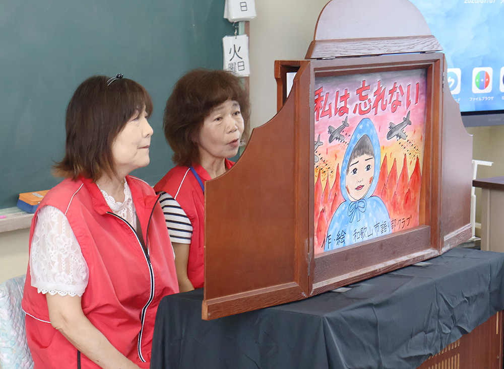 児童たちに読み聞かせる岸淵さん㊧と外畑さん