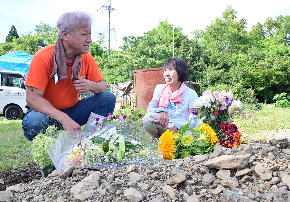 埋葬された太郎の前で思い出を話す山田さん㊧