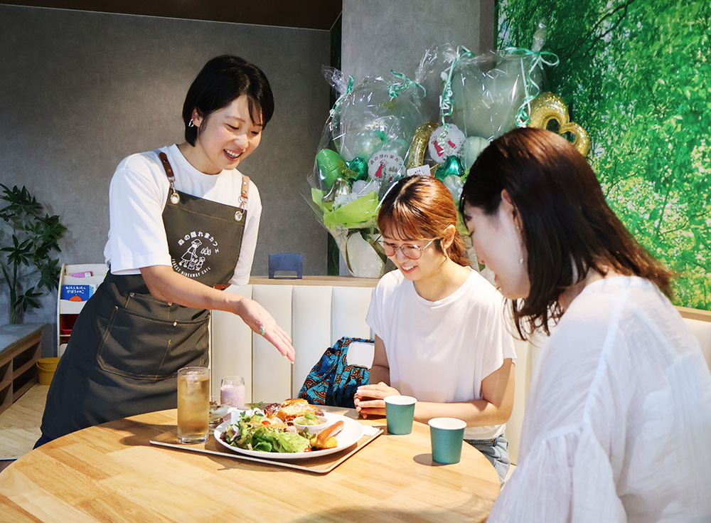 メニューの説明をする山尾さん㊧