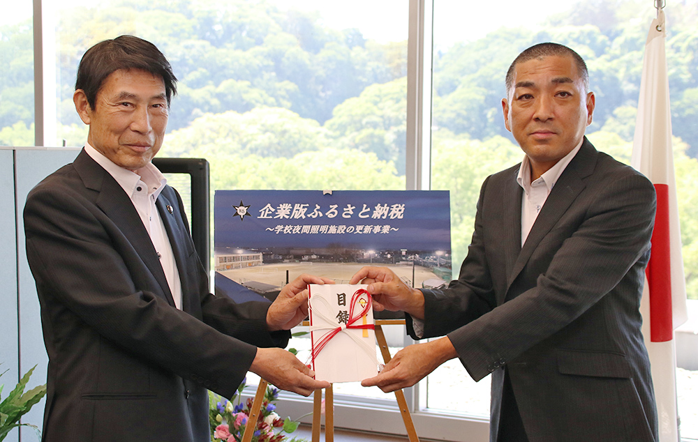 目録を手に平野代表取締役㊨と尾花市長