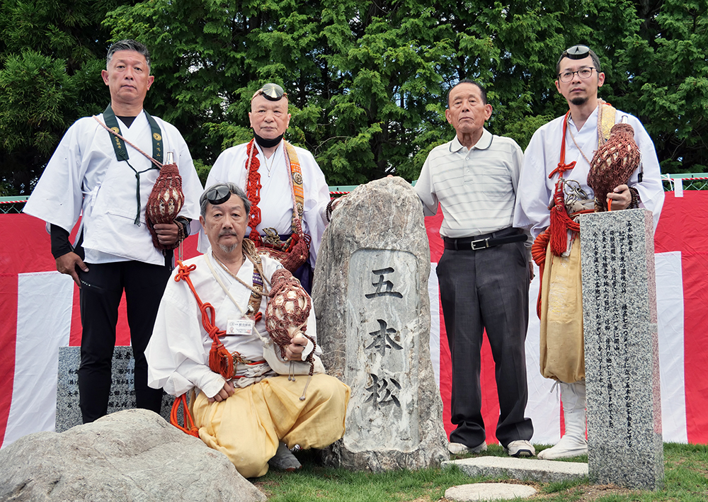 完成を祝う林さん（後列左から３人目）と冨士さん（同２人目）ら修験僧の皆さん