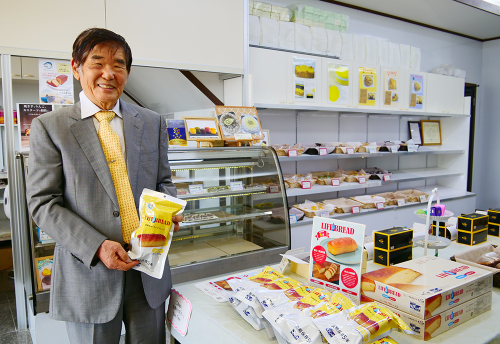 ライフブレッドを手に笑顔の中里社長