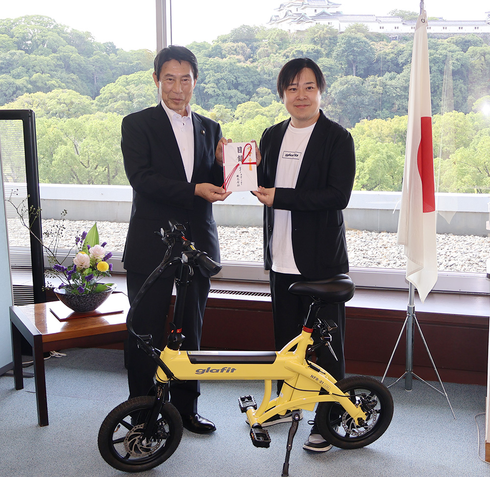 尾花市長㊧に目録を手渡した鳴海代表取締役