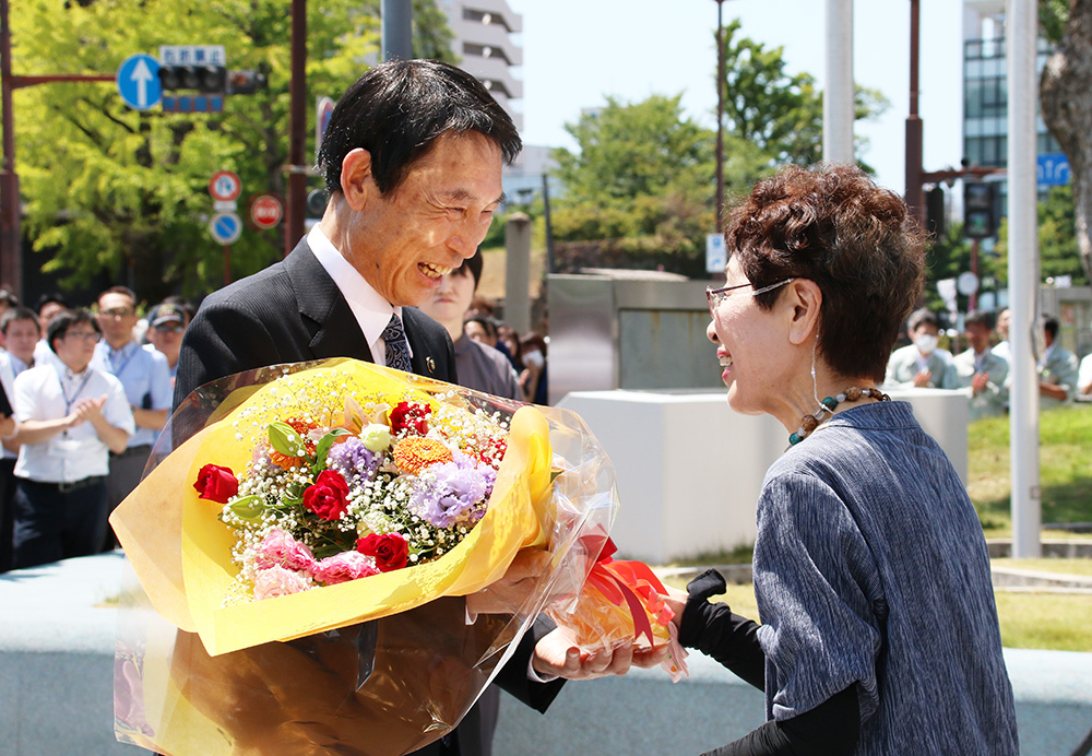 退庁式で花束を受け取る尾花市長㊧