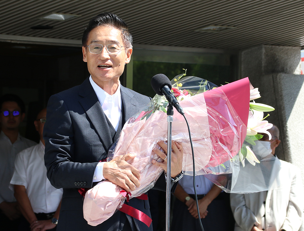 花束を手に初登庁式であいさつする尾﨑市長
