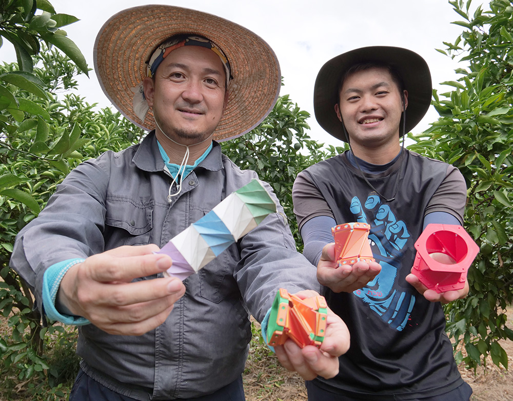 木を守る保護具を開発した小倉さん㊧と従業員の城本海人さん