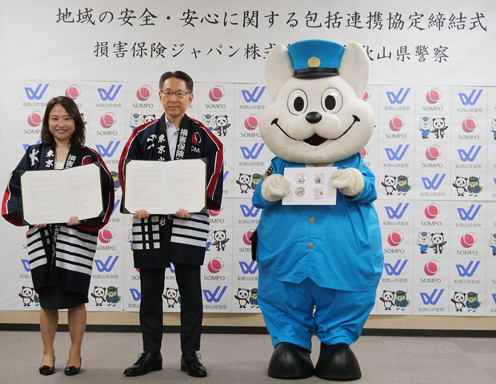 きしゅう君と共に協定書を手にする(左から)大西支店長、壱岐県警本部長