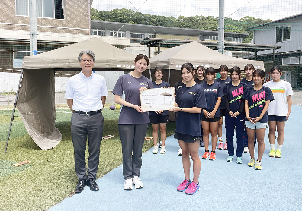 目録を手に笑顔の松本さん(左から2人目)と井端主将ら(タカショー提供)