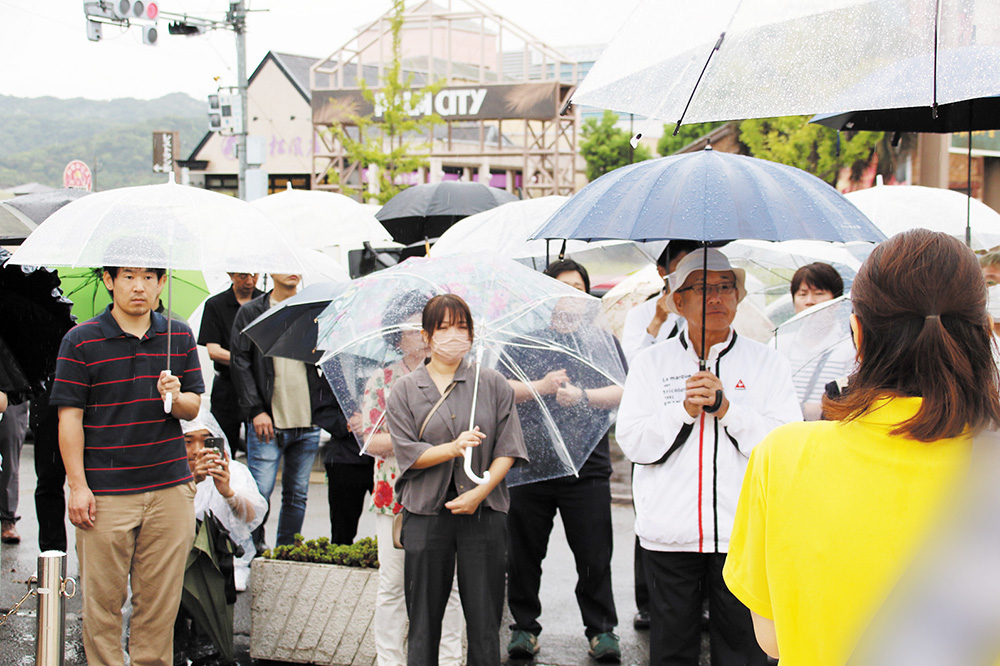 雨の中、候補者の訴えを聞く有権者ら