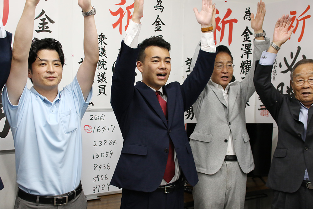 万歳で当選を喜ぶ金澤さん(中央)